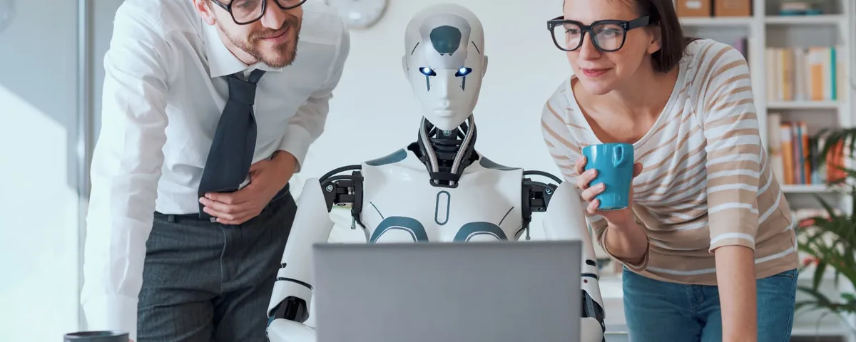Equipo de trabajo junto a un robot humanoide mirando una notebook
